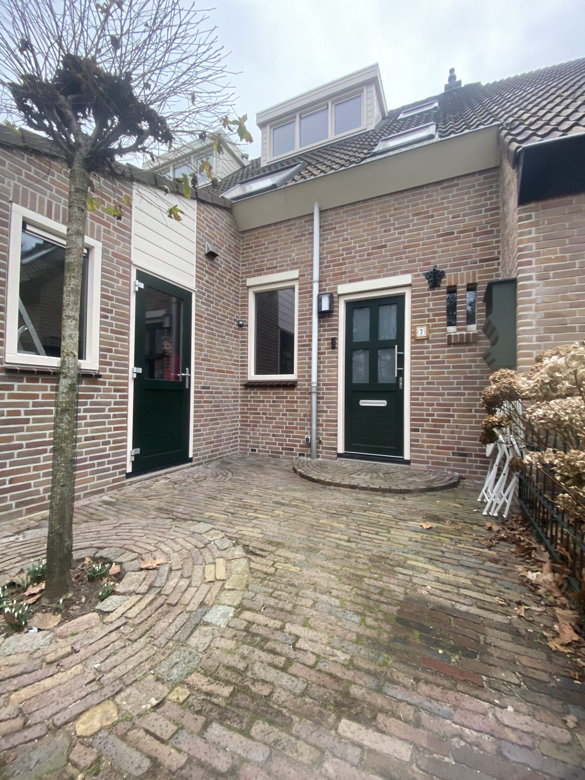 Donkergroene kozijnen en deuren met witte omlijsting rond een binnenplaats