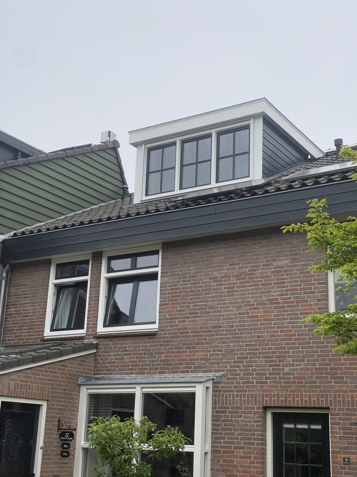 Witte dakkapel met plat dak en roedeverdeling in de ramen