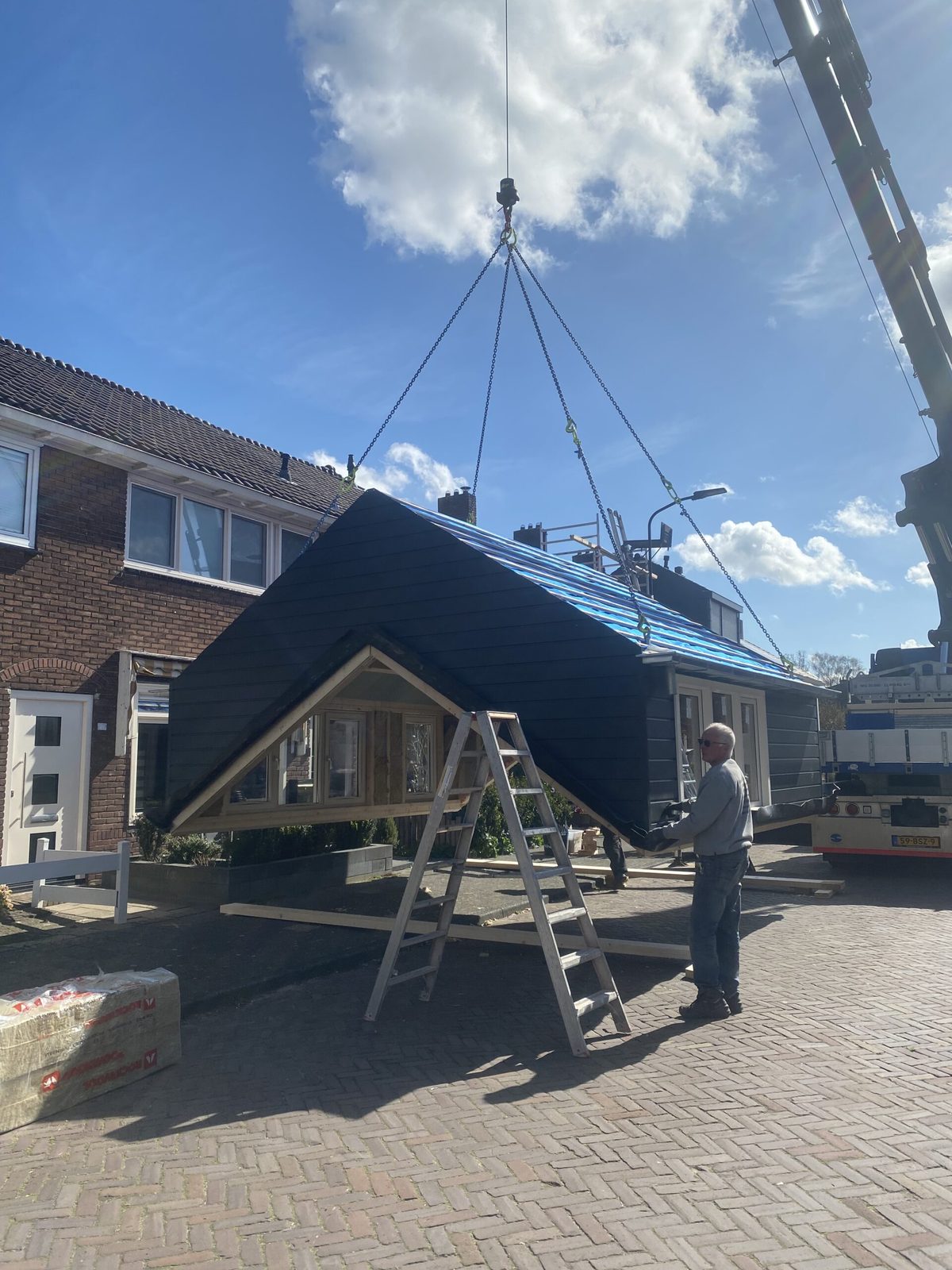 Prefab dakopbouw wordt met een kraan op het dak van een woning geplaatst