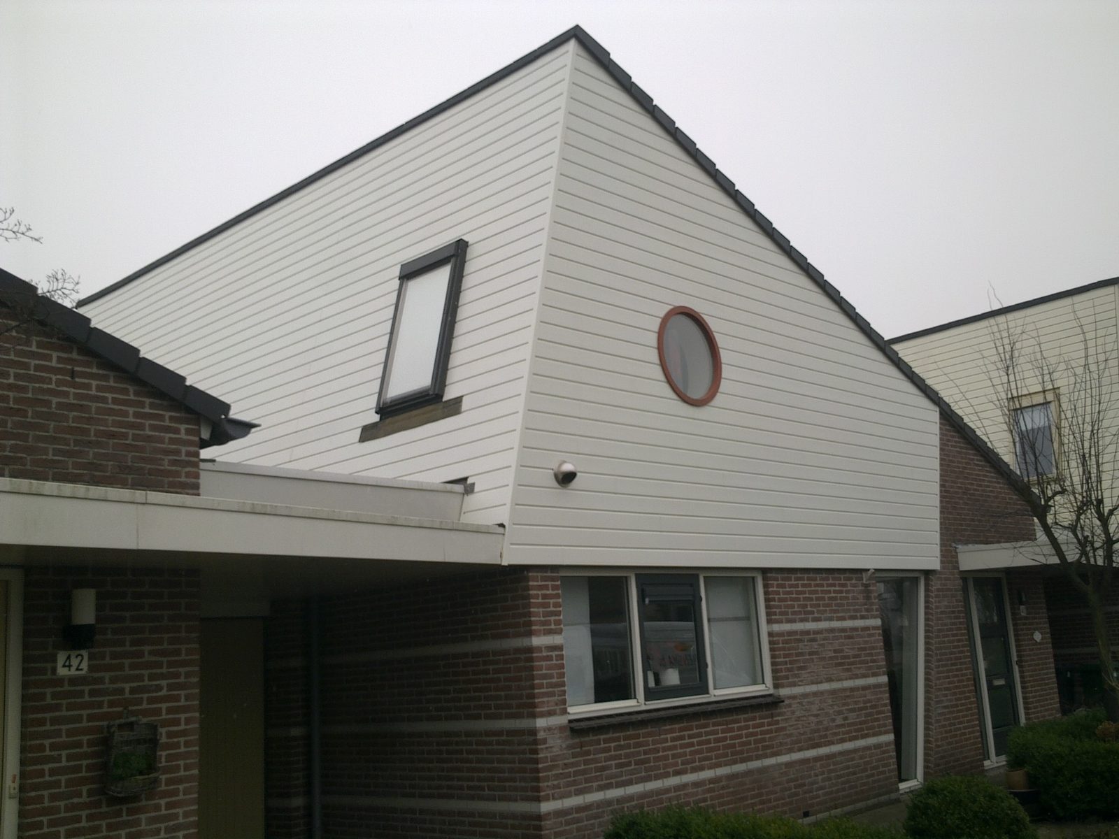 Kopgevel bekleed met cremekleurige horizontale gevelbekleding